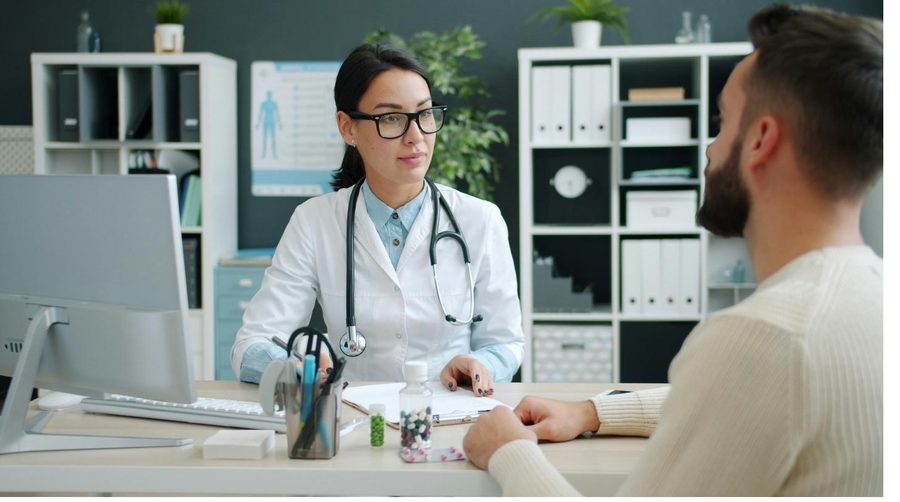 A physician reviewing a case with a patient at a desk