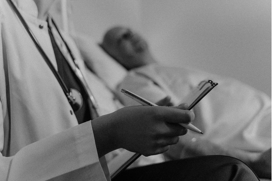 A clinician writing notes on a medical chart